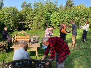 Volunteers working together with Äijälä clients and getting to know traditional work methods. Photo